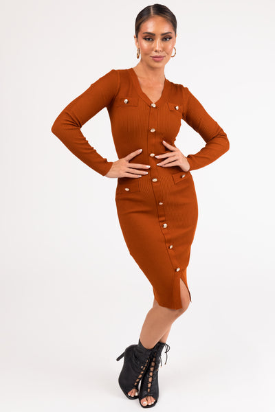 A woman modeling a long sleeve ribbed midi dress with button details in a rust color.